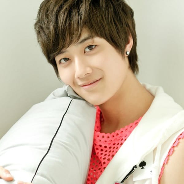 Lucky has dark brown hair. He wears a white jacket vest with a spade card on it, with a light pink shirt that is covered in holes